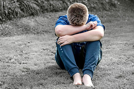 Young boy crying with head in his hands